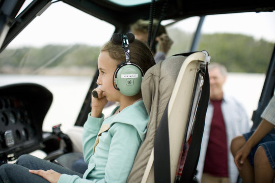 Girl talking with headphone while sitting in helicopter
