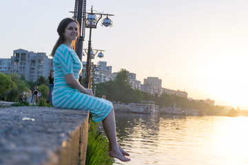the girl is sitting on the parapet
