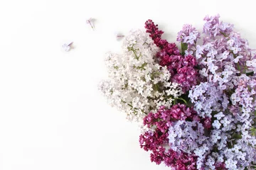 Poster Im Rahmen Styled stock photo. Spring feminine scene, floral composition. Bunch of beautiful blossoming purple and white lilac branches. White table background. Flat lay, top view. © tabitazn