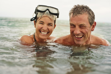 Portrait of a happy mid adult couple swimming in the ocean together.