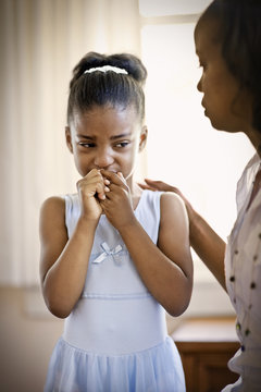 Sad little girl being comforted by her mother