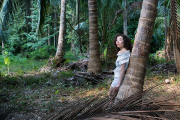 Naklejka na ściany i meble Pretty young woman of mixed race in the tropical forest..