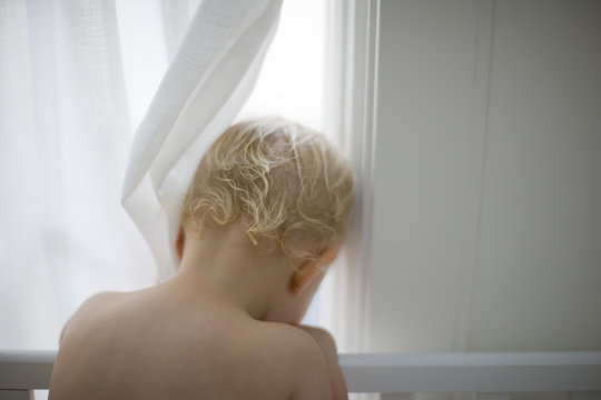Toddler looking out a window.