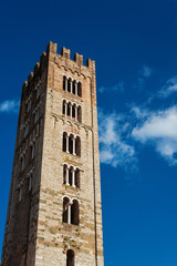 Fototapeta na wymiar Saint Fridanius Basilica old medieval bell tower in the town of Lucca, Tuscany. Erected between the 12th and 13th century (with clouds and copy space)
