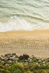 Aerial view of a beautiful tropical beach with waves at sunset