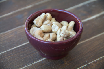 cashew nuts inside bowl on a wooden table seen close up