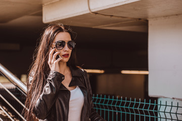 Woman talking on the phone. Authenticity and Spontaneity. Authentic conversation over the phone. The girl in sunglasses holds a mobile phone in hand.