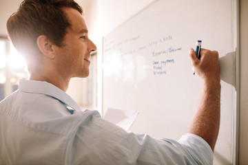 Fototapeta premium Man writing on whiteboard with marker pen