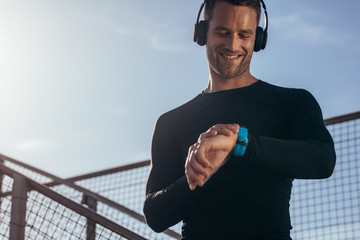 Naklejka premium Athlete using smartwatch to monitor his progress