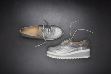 Silvery sneakers on grey background.