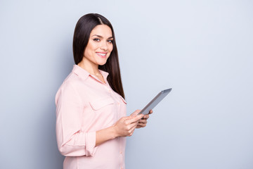 Portrait with copy space empty place of pretty charming confident trendy woman in classic shirt having tablet in hands looking at camera isolated on grey background