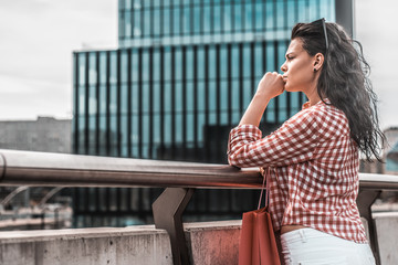 Fototapeta premium A concentrated woman looks ahead. Shopping concept. Vintage and toned color portrait of girl. Female goes out with shopping bags from the shopping center.