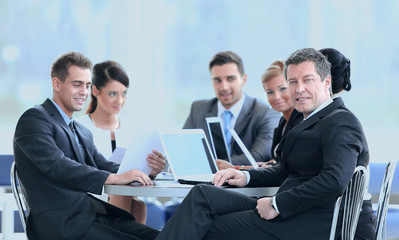 businessman and his business team with financial documents sitting at a Desk in the lobby of the Bank.