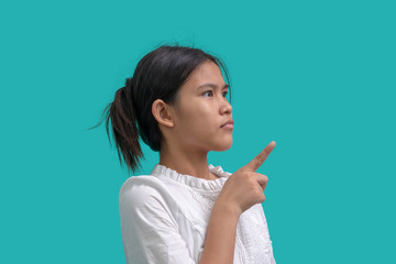 Portrait of teenage girl pointing finger on green background