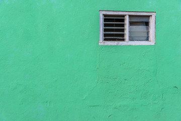 Small window on a green wall