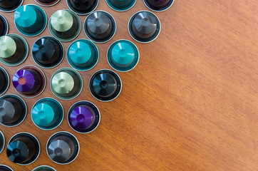 Colored espresso coffee capsules, machine coffee, on wooden background.
