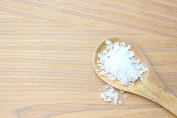 Table salt on wooden ladle