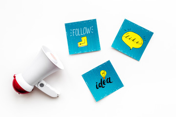 Socail media announcements concept. Megaphone near social media icons on white background top view