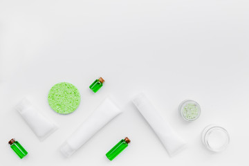 Organic skin care products. Cream, lotion, tonic. oil near green leaves on white background top view pattern
