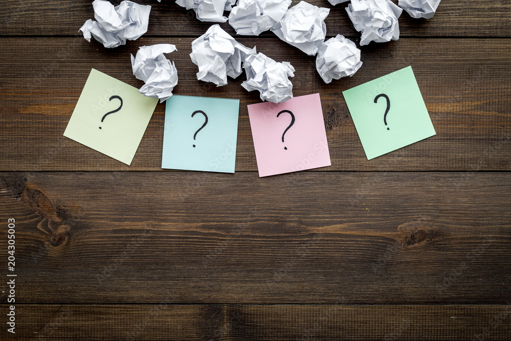 Poster faq concept. question mark on sticky notes near crumpled paper on dark wooden background top view co