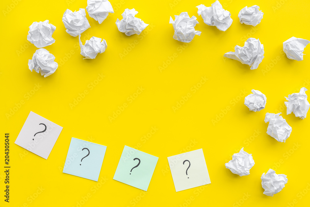 Poster faq concept. question mark on sticky notes near crumpled paper on yellow background top view copy sp