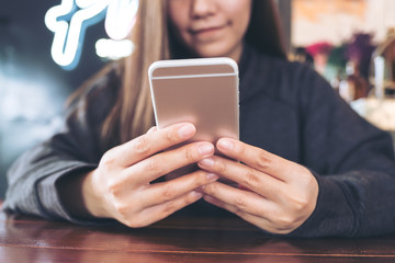 Closeup image of a woman holding , using and looking at smart phone