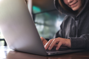 Closeup image of a woman working and typing on laptop keyboard on the table