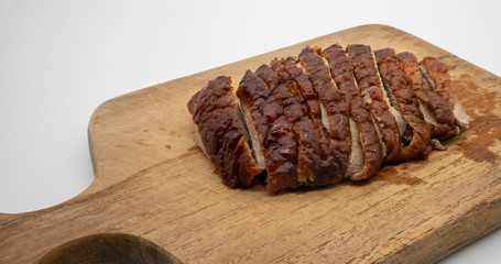 Roasted duck on wooden cutting board isolated on white
