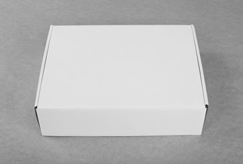 Closed white cardboard box for packaging on a white background.