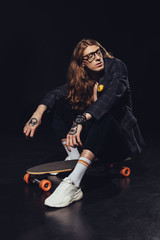 fashionable man posing with longboard, on black