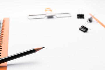 Copy space blank paper A4 and pencil and back binder clip on table white background ,top view