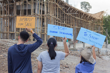 Standing child holding a sign, anti-trafficking, stopping violent acts against children, stopping child labor.