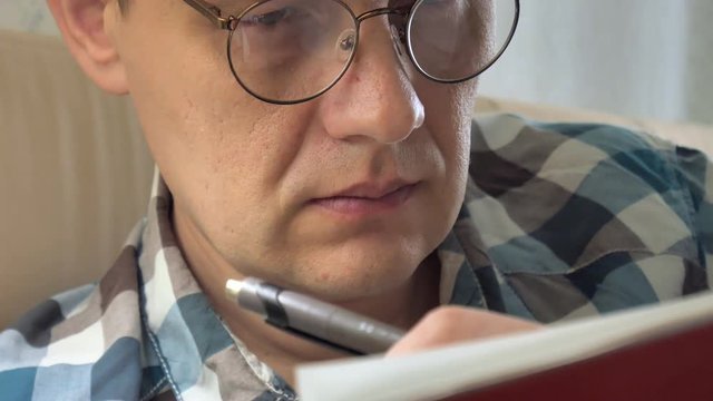 Close up, shot of a business man holding a pen, thinking and making notes in notebook during training.