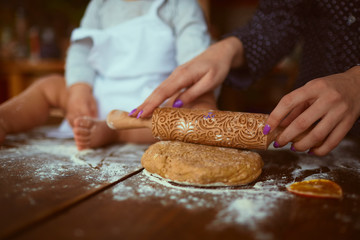 The mother with son knead the dough in the kitchen