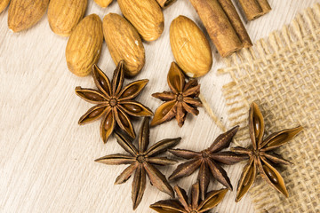 Fototapeta na wymiar anise and almonds scattered on a wooden board. Oriental spices