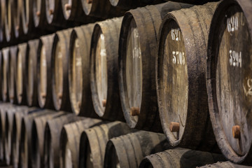 Row of wooden porto wine barrels in wine cellar Porto, Portugal.