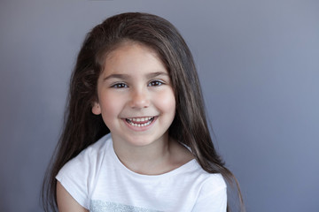 Portrait of a happy smiling brunette child girl with long hear