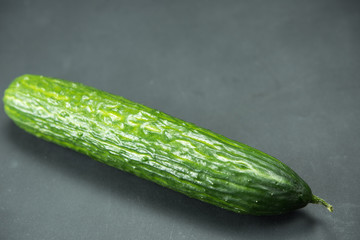 cucumber, isolated on a black background. Black paper, horizontal