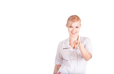 Woman in white medical suit points finger at screen isolated on white background. Girl doctor, nurse with glasses extends hand and finger forward