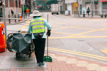Woman city street cleaner working cleaning in the morning at Hong Kong.