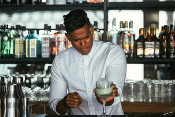 Concentrated bartender making cocktail