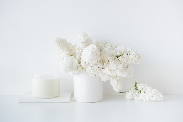 Fototapeta na wymiar Minimalist white home decor, fresh lilac flowers bouquet in vase
