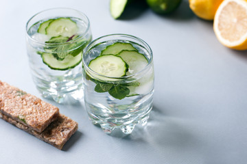 Detox water infused with sliced cucumber and springs of mint, copy space