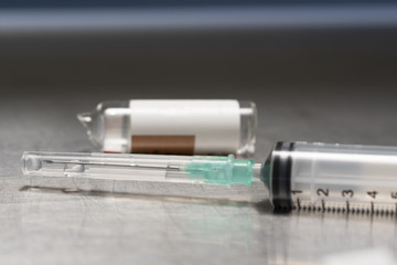 Medication in a syringe and broken vial