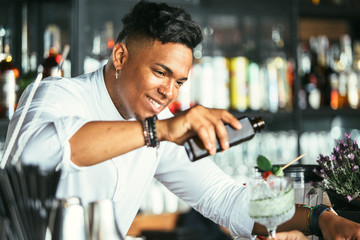 Smiling bartender serving cocktail