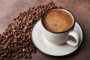 Coffee in a white cup with roasted beans