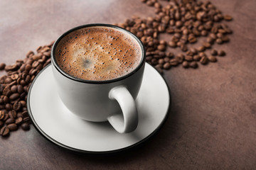 Coffee in a white mug with roasted beans