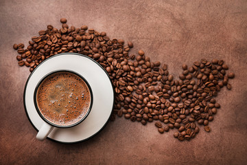 Coffee in a white cup with roasted beans