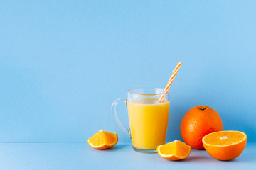 Orange juice on a blue pastel background