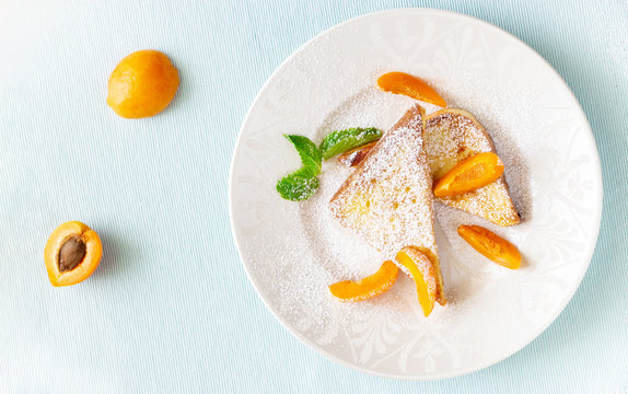 French toasts with fresh cut apricot, mint and icing powder. Healthy classic breakfast concept. Top view.